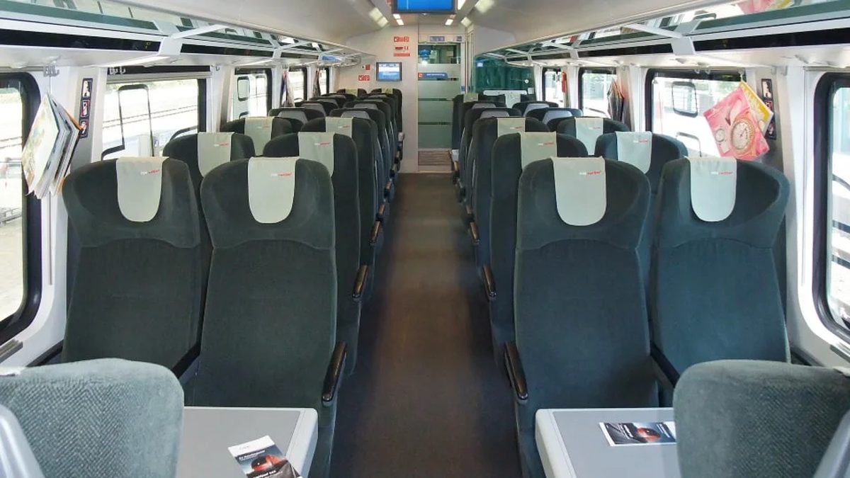 First Class cabin on an ÖBB Railjet Vienna to Zurich train, deep green velour seats with cream headrest covers and tray tables